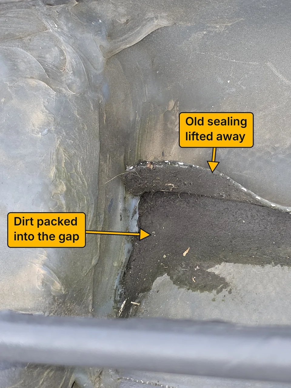 Close-up of the damaged flashing area before the repair, with the old sealing lifted away and the gap packed with dirt. Labels point to each.