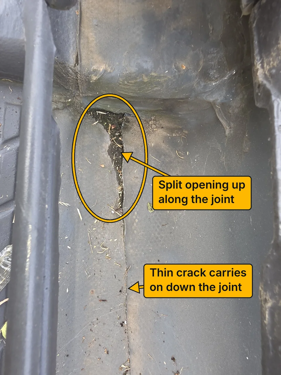 A split running along a joint in the flashing before the repair, with dirt and debris packed in the opening. Labels point to the split and to the thin crack that carries on down the joint.